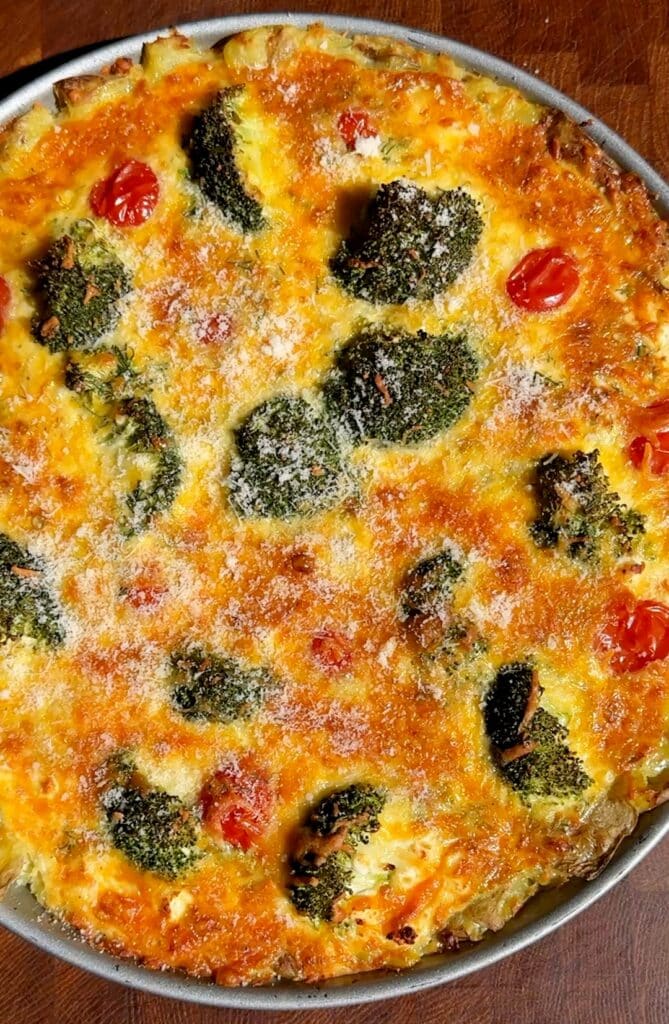 Whole baked potato crust quiche with broccoli and melted cheddar cheese, golden and crispy on top