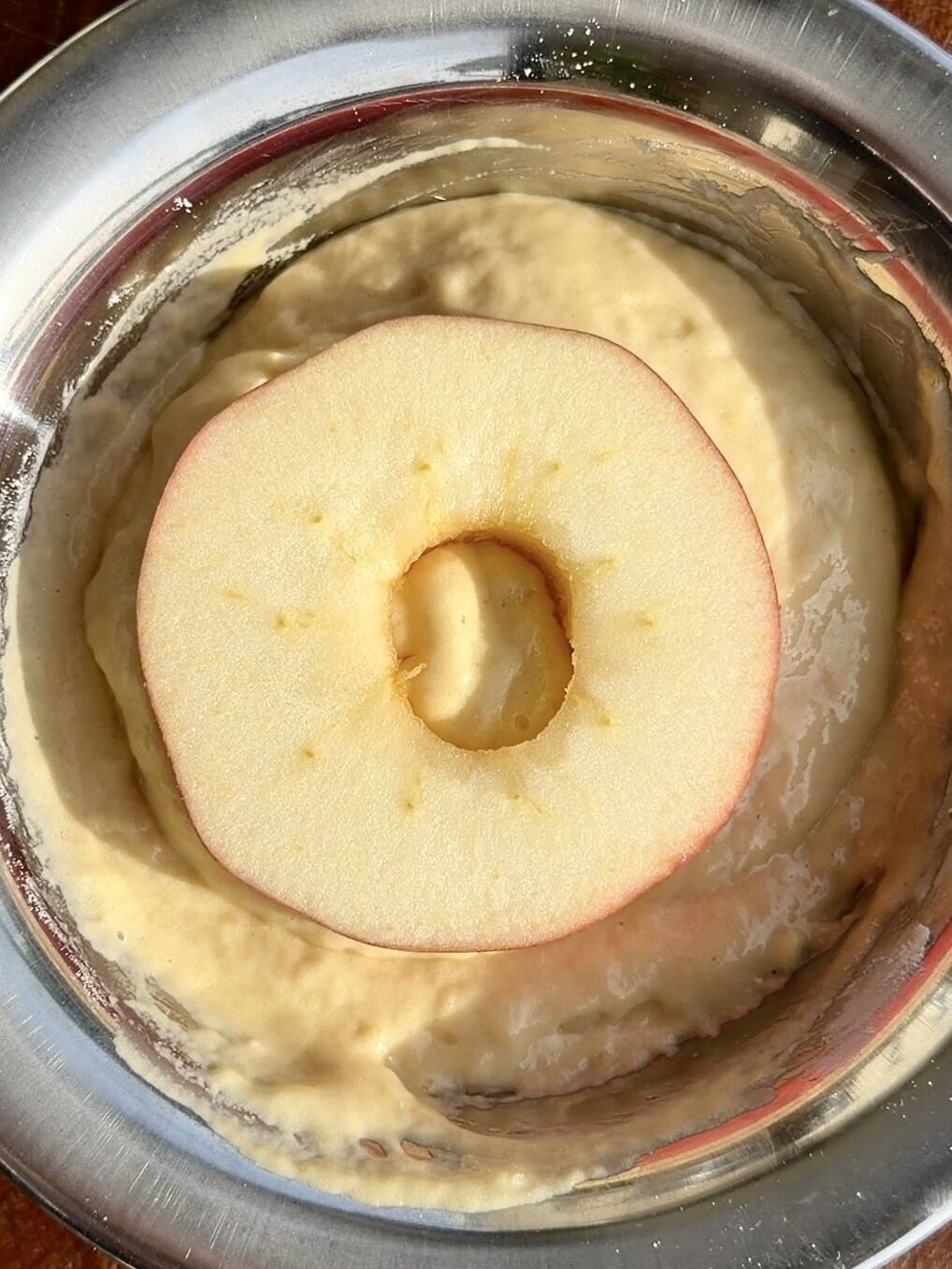 Light and airy apple ring batter in a bowl, made with whipped egg whites folded into flour, milk, and vanilla for a fluffy texture.