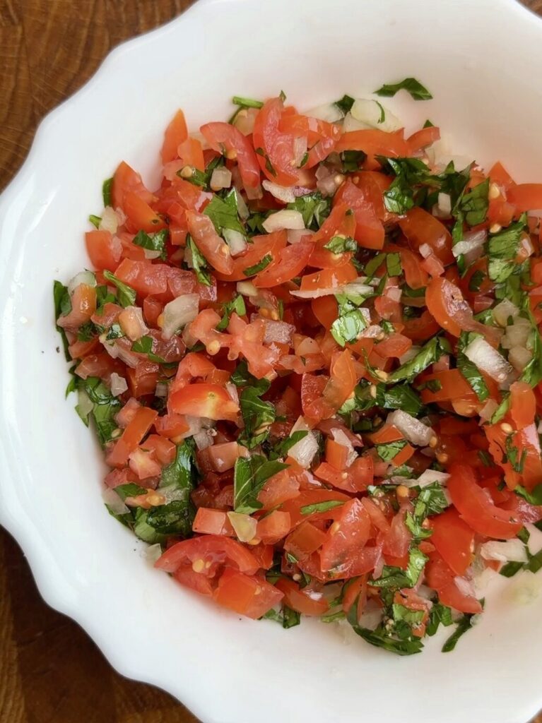 Freshly diced onion, tomatoes, and cilantro mixed with lemon juice to make vibrant homemade salsa for tacos.