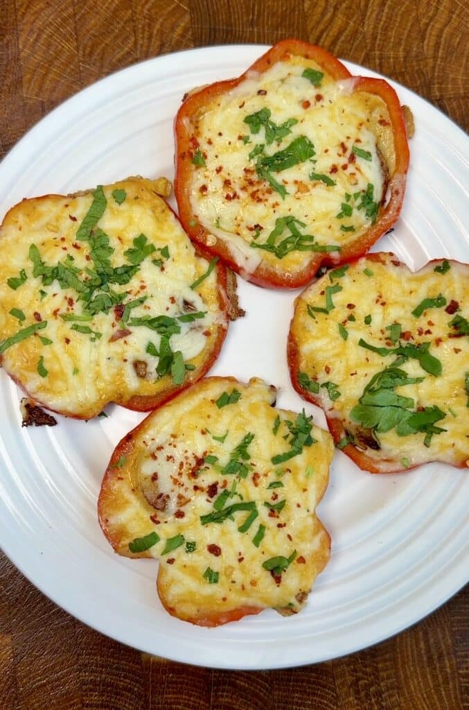 Cheesy potato pepper rings served on a plate, garnished with chili flakes and fresh parsley, ready to enjoy as a delicious breakfast or brunch.